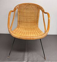 front view of wicker bamboo armchair on iron legs