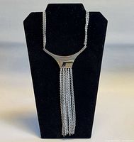 Front view of necklace displayed on stand showing pendant and fringe