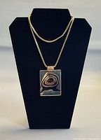 Pendant on display bust showing size and chain