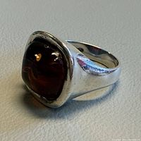 Side perspective of sterling silver ring showing amber cabochon and band taper