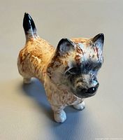 Front angled view of glazed porcelain terrier figurine