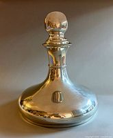 Full front view of pewter decanter with stopper