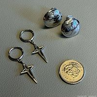 Group view of both earring pairs with coin for scale