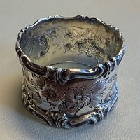 Side view showing floral repoussé pattern and scalloped rim