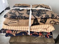 Stacked bundle of four folded fabrics tied with tape showing edges and thickness