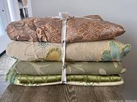 Stacked bundle of five folded fabrics tied with string