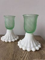 Pair of assembled candle holders showing milk glass bases and green inserts