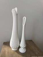 Front view of both milk glass vases side by side on table