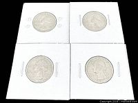 Front view of four Bicentennial quarters in holders