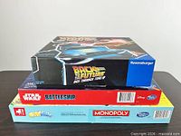 Stack of three board game boxes showing titles and brands