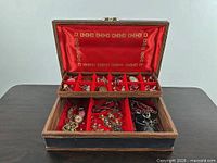 Open wood/leather jewelry box with jewelry visible