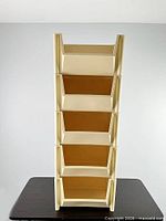 Front view of five stacked beige plastic bins