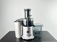Front view of Breville JE95XL juicer with pulp bin and juice pitcher attached