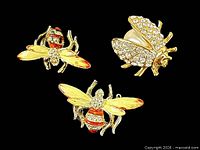 Front view of three brooches: two bees, one ladybug beetle