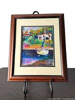 Full view of framed painting on stand showing frame, mat and artwork