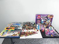 Overview of boxed and bagged LEGO sets with loose pieces on table