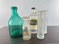 group shot of all five vintage glass bottles