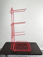 Right side profile showing three vertical hook arms and slatted base