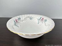 Side view of round fluted bone china bowl with floral pattern and gold edge