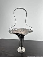 Full view of basket front, showing pedestal base, bowl and handle