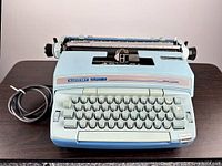 Front view of Smith-Corona Coronet Super 12 typewriter with power cord on table