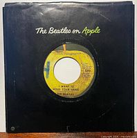 Front of black Apple company sleeve showing record inside