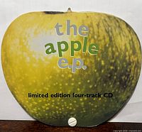 Front of apple-shaped sleeve showing title graphics