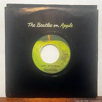 Front view of record in black Apple company sleeve