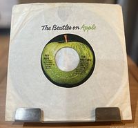Front view of record in white Apple company sleeve
