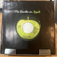 Front of black Apple company sleeve with record inside