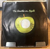 Front of sleeve displaying record through die-cut and Apple logo