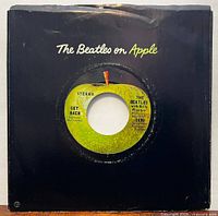 Record in black Apple sleeve showing label through center