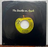 Front view showing record in black Apple company sleeve