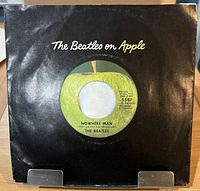Front view of record in black "The Beatles on Apple" sleeve on stand