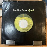 Front of record in black Apple sleeve showing B-side label through die-cut center