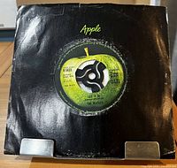 Front of black Apple company sleeve showing center cut-out with Side 1 label visible