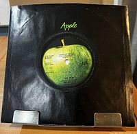 Record in black Apple sleeve showing A-side label