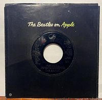 Record in black Apple company sleeve front view