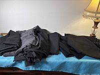 Stack of folded black fabric pieces on blue cloth