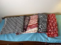 Four folded batik fabric pieces in varied colours on blue cloth