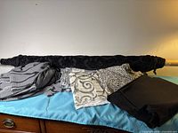 Group shot of five fabric pieces including rolled bolt and folded fabrics