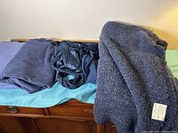 Four different blue fabrics spread on surface