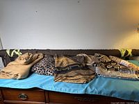 View of all folded fabrics and brown fabric roll on table