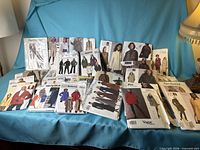Full lot of approx. 26 coat and outerwear sewing patterns on sofa