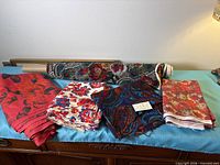 Overview of six floral fabrics on surface including roll