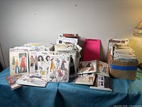 Wide view of multiple stacks and boxes of dress patterns on table