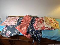 Six folded pieces of floral polyester satin fabric displayed on table