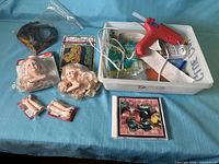 Full lot showing glue gun, doll heads, limbs, craft floss, feathers, tray
