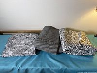 Three folded fabric pieces: illustrated print, houndstooth, rose outline