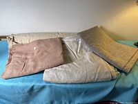 Four fabric pieces in neutral tones displayed on table